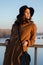 Beautiful young lady standing on bridge watching autumn sunset