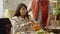 A beautiful young lady is taking the pulp out of the pumpkin and a young man is watching