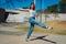 Beautiful young latina dancing happily in the street while partying with jumps and somersaults. Concept of joy, street dance, hip