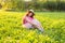 Beautiful young laughing naughty woman sitting on the grass and smiling