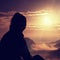 Beautiful young long hair girl tourist enjoy daybreak on the sharp corner of sandstone rock and watch over valley to Sun.