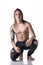 Beautiful young long haired man shirtless, kneeling on the floor