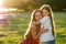 Beautiful and young long-haired woman playing with her daughter embrace and caress in a summer day in the park . happy