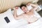 Beautiful young man wake up on bed in the morning with phone on pillow