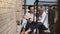 Beautiful young man and woman sitting barefoot close together talking with coffee at a lovely sunny apartment balcony.