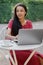 Beautiful and young millennial African woman in a public place working on a laptop