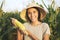 Beautiful Young Mixed Race Farmer Woman in Hat with Ripe Corn at Organic Farm Field. Woman Smiling and Showing Thumb Up at Camera