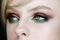Beautiful young model with green-brown smoky eyeshadow evening make up, perfect skin. Close-up face portrait