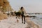 Beautiful Young Mother and Cute Little Boy Son Walking and Enjoying the Nice Outdoor Weather on the Sandy Beach next to the Ocean