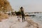 Beautiful Young Mother and Cute Little Boy Son Walking and Enjoying the Nice Outdoor Weather on the Sandy Beach next to the Ocean