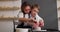 Beautiful young mother and her cute baby boy son studying pottery on potter wheel in studio. Handmade ceramic workshop