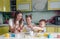 A beautiful young mother with two children decorated traditional Easter eggs with bright paint, the concept of a happy family.