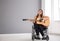 Beautiful young musician in wheelchair playing guitar indoors