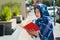 Beautiful young muslim woman wearing blue colored hijab, holding thick reed book and reading in street, outdoors urban