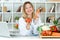 Beautiful young nutritionist looking at camera and holding fresh vegetables in the consultation.