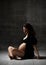 Beautiful young pregnant happy mother woman posing in underwear on dark