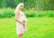 Beautiful young pregnant woman with chamomiles flowers in summer