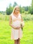 Beautiful young pregnant woman with chamomiles flowers in sunny summer