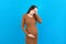 Beautiful young pregnant woman feeling head ache on colored background isolated. Stressed pregnant woman or mother