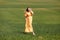 Beautiful young pregnant woman in long dress in the green field on summer day. Happy maternity and pregnancy concept