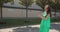 Beautiful young pregnant woman smiling feel happy walking on street. Pregnant beautiful woman in a green dress. Close up