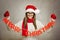 Beautiful young Santa girl with Merry Christmas text decoration