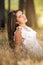 Beautiful young serene woman sitting in a meadow