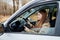 Beautiful young sexy woman in car looking from window and autumn forest ackground