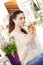 Beautiful young smiling woman with croissant and a cup of coffee in her hands at the cafe coffee bar, ice cream shop and pastry