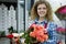 Beautiful young smilling woman florist are selling the bouqet of the roses in flower shop