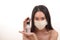 Beautiful young south east Asian woman three ply anti virus surgical face mask posing holding using squeeze transparent liquid