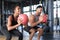 Beautiful young sports couple is working out with medicine ball in gym