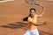 Beautiful young sportswoman, professional tennis player with racket practicing on clay tennis court in summer day.