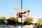 Beautiful young strong woman making a pose on a pole