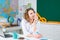 Beautiful young teacher standing near blackboard. Young female student preparing for exams.