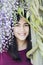 Beautiful young teen girl under wisteria vines