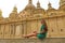 Beautiful young tourist woman sitting on wall looking at stunning Basilica of Our Lady of the Pillar in Zaragoza, Spain