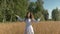 Beautiful young white woman singing with happiness on the field with wheat.