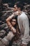 Beautiful young wild free couple in tribal costumes at the stone background