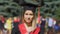 Beautiful young woman in academic dress looking to camera, successful graduate