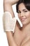 Beautiful young woman applying scrub glove on her perfect skin
