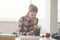 Beautiful young woman architect is keeping notes in her office