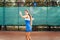 Beautiful, young woman athlete enjoys spending time on the tennis court. Powerful blow forehand. Preparing to receive the ball