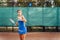 Beautiful, young woman athlete enjoys spending time on the tennis court. Powerful blow forehand. Preparing to receive the ball