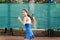 Beautiful, young woman athlete enjoys spending time on the tennis court. Powerful blow forehand. Preparing to receive the ball