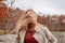 Beautiful young woman in autumn park. Face hidden behind hair, wind blowing hair of beautiful girl outdoor