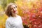 Beautiful young woman in autumn park. Season and people concept. Blonde fashion model having fun in fall park outdoors.