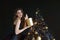 Beautiful young woman on the background of a Christmas tree. A New Year& x27;s gift. Black background.