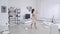 Beautiful young woman with bare feet and a beige dress moves in the interior in the living room in slow motion.