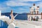 Beautiful young woman and bells on Santorini island